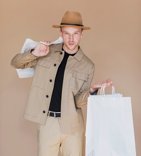 Man with brown hat holding the shopping bags