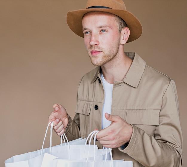 Foto gratuita uomo con cappello marrone e reti commerciali