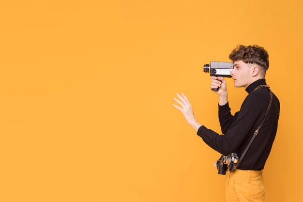 Man with a camcorder in a yellow scene