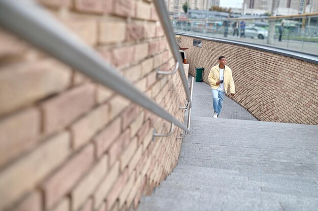 Man with camera climbing stairs looking to side