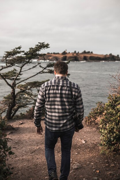 Man with camera walking towards river