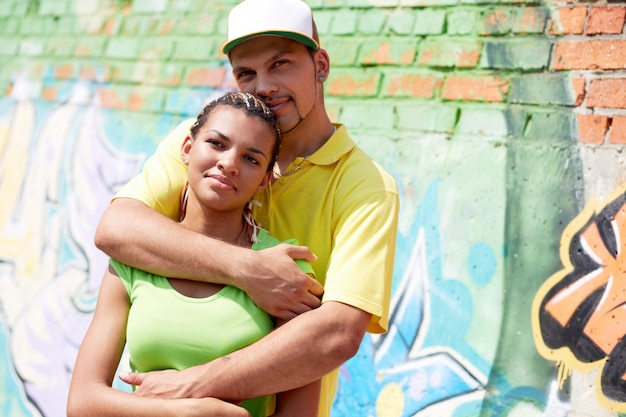 Man with cap hugging his girlfriend