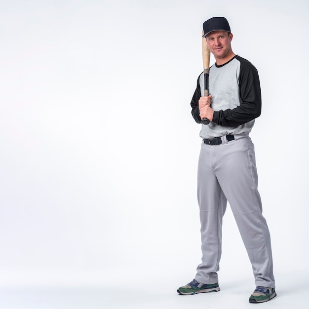 Man with cap posing with baseball