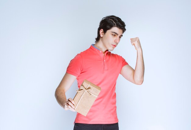 Man with a cardboard gift box showing his fist.