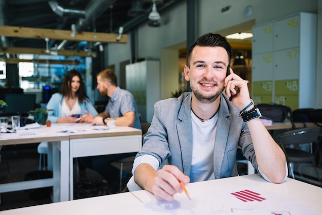 Man with charts and talking on phone