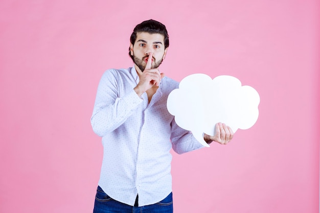 Man with a cloud shape board asking for silence. 