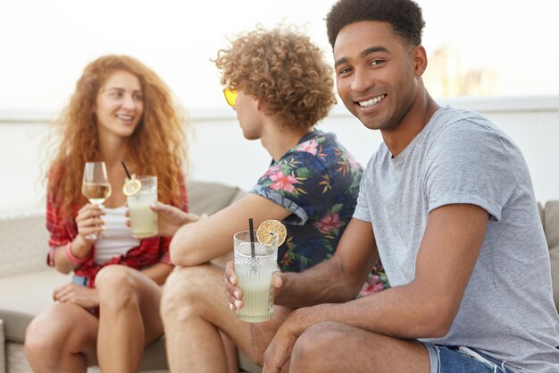 man with cocktail looking and smiling at camera