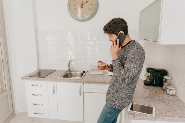 Man with coffee seaking on phone