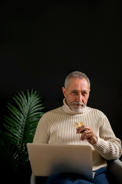 Man with credit card and laptop looking at camera