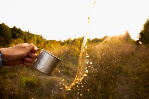 Man with cup splashing water in air