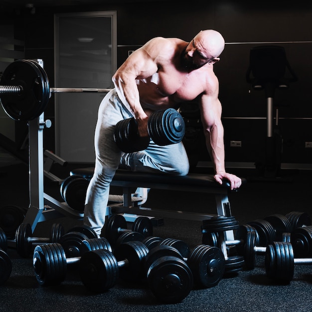 Man with dumbbell looking over shoulder
