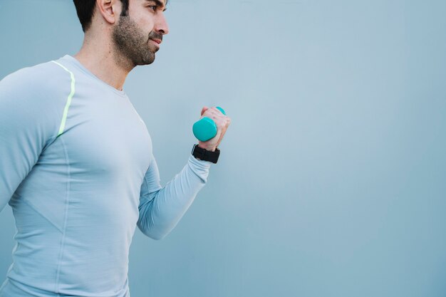 Man with dumbbell at wall