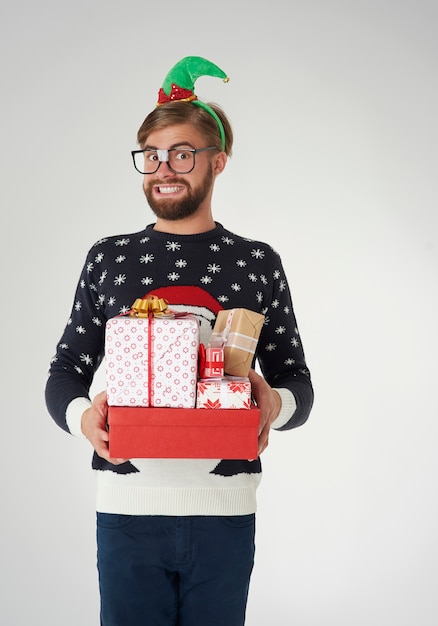 Man with elf hat and many Christmas gifts