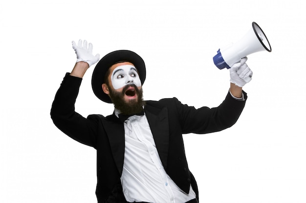 Man with a face mime screaming into megaphone