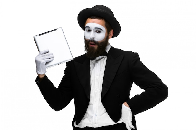 Free photo man with a face mime working on a laptop isolated on a white