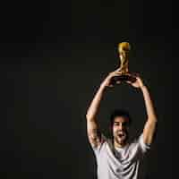 Free photo man with fifa trophy celebrating victory