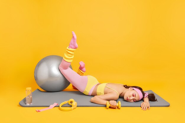  man with fitball headphones dumbbells bottle of water around 