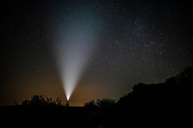 Man with flashlight enjoys the beauty of nature