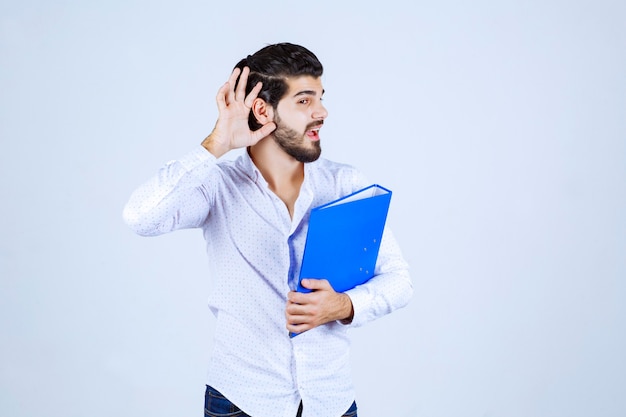 Man with folder pointing his ear to hear well