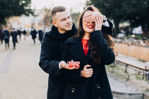 Man with gift surprising young woman