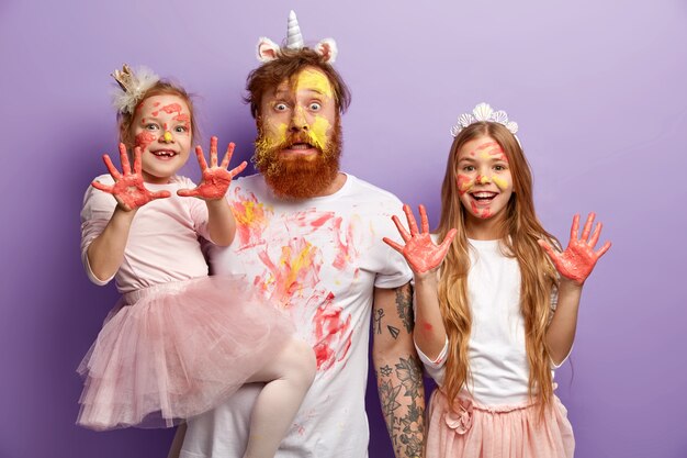 Man with ginger beard and his daughters wearing dirty clothes