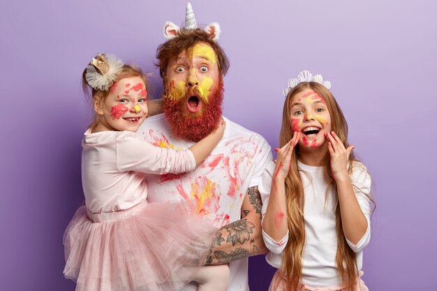 Man with ginger beard and his daughters wearing dirty clothes