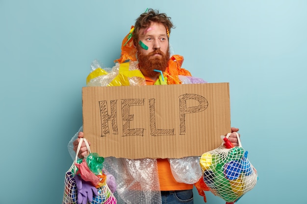 Free photo man with ginger beard holding bags with plastic waste