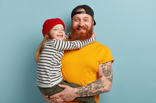 Uomo con la barba allo zenzero che tiene sua figlia