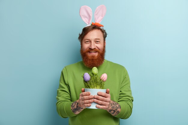 Uomo con barba allo zenzero che indossa abiti colorati e orecchie da coniglio