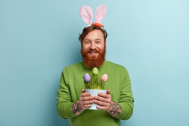 Man with ginger beard wearing colorful clothes and bunny ears