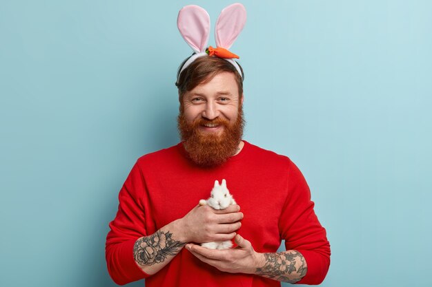 Man with ginger beard wearing colorful clothes and bunny ears