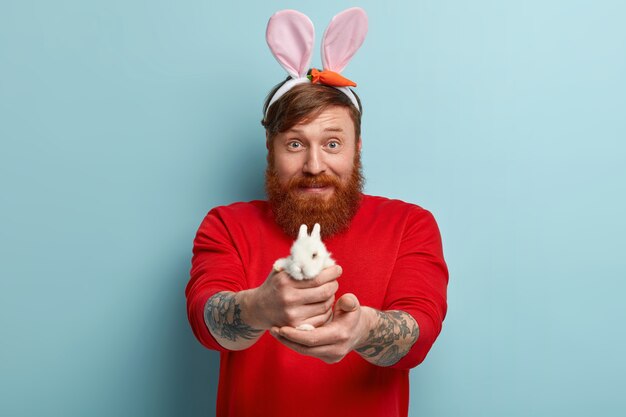 Man with ginger beard wearing colorful clothes and bunny ears