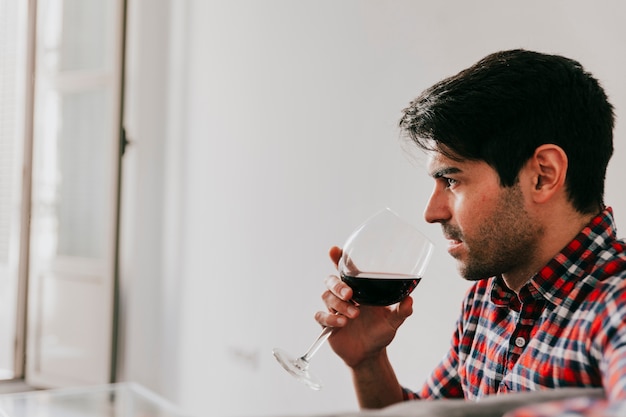 Uomo con un bicchiere di vino rosso