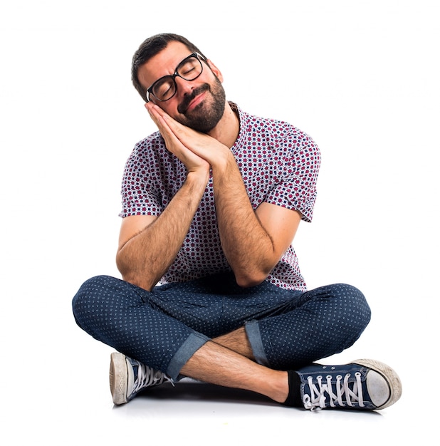 Free photo man with glasses doing sleep gesture