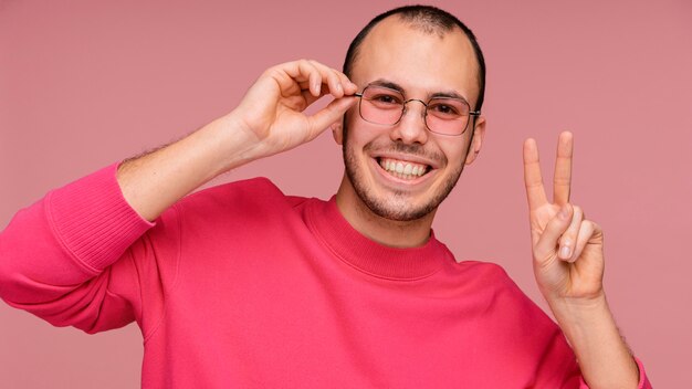 Man with glasses laughing and showing peace sign