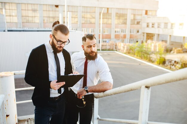 バックグラウンドで別の男とタブレットを見て眼鏡をかけた男