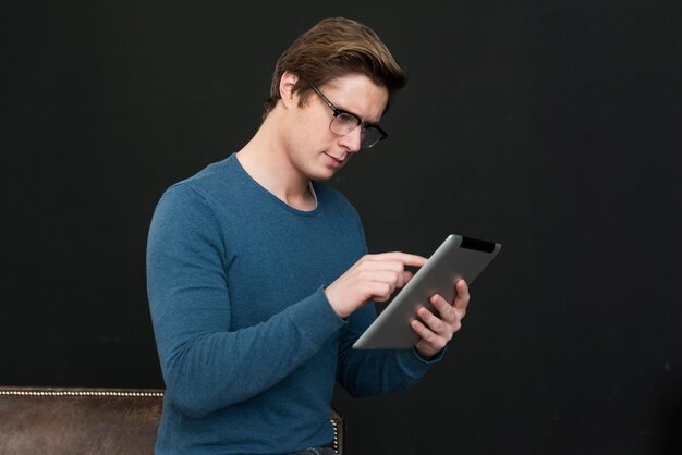 Man with glasses looking on tablet