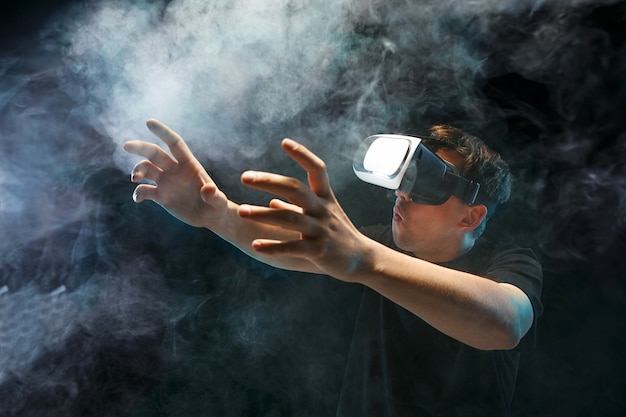 Человек в очках виртуальной реальности. Концепция будущей технологии. Черная студия дымчатый