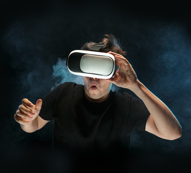 Человек в очках виртуальной реальности. Концепция будущей технологии. Черная студия дымчатый