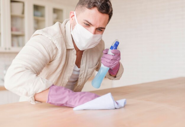 Man with gloves holding disinfectant