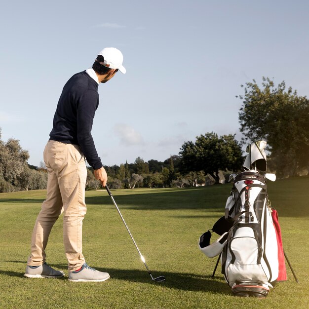 Uomo con mazza da golf sul campo da gioco