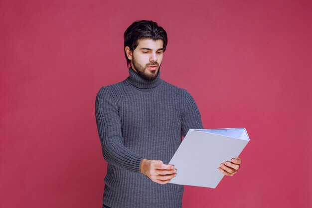 Man with grey folder offering or recieving it. 