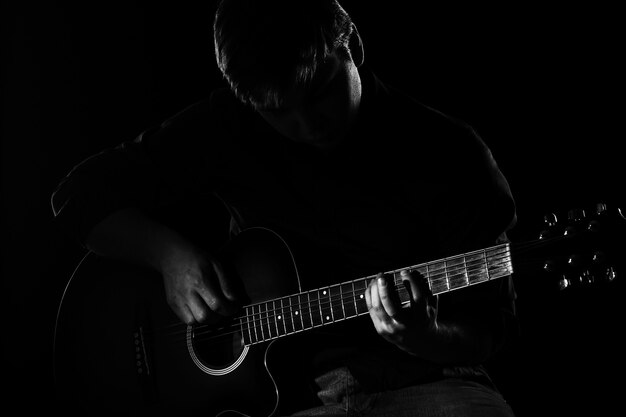 Человек с гитарой в темноте