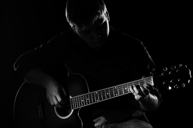 Free photo man with guitar in darkness