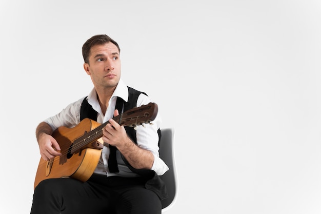 Man with guitar in studio copy space