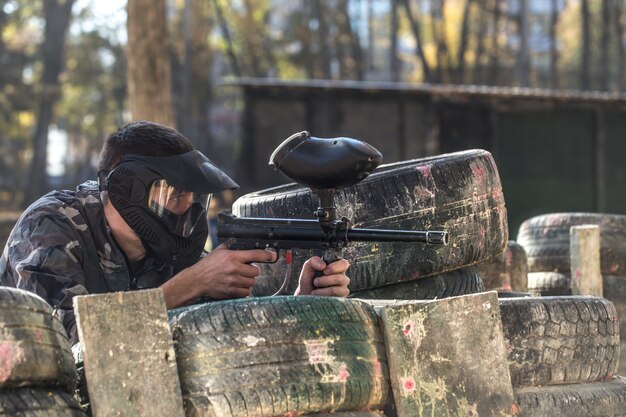 ペイントボールをしている銃を持った男。