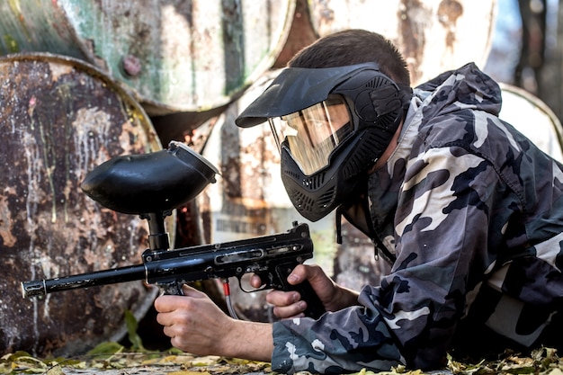 A man with a gun playing paintball.