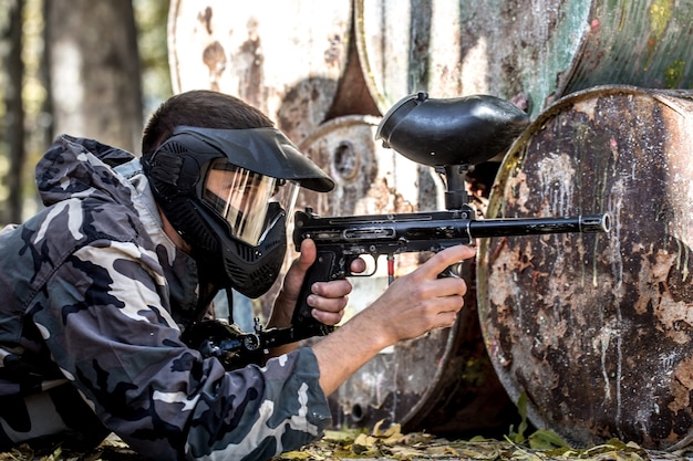 A man with a gun playing paintball.