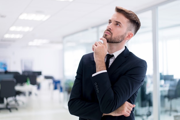 Man with hand on chin and looking at the ceiling