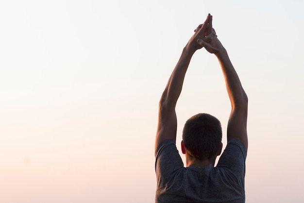 Foto gratuita uomo con le mani in aria guardando il cielo